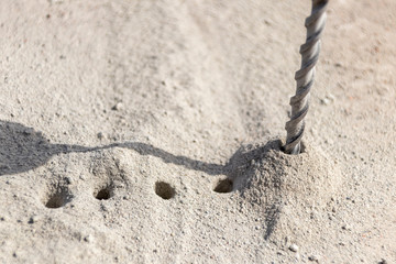 People are using electric drill,He drilled concrete to put steel anchor.