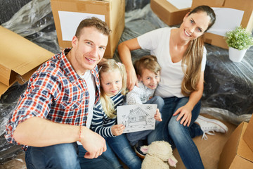 Eltern und Kinder mit Bild vom Eigenheim