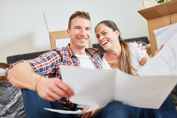 Lachendes junges Paar mit Bauplan