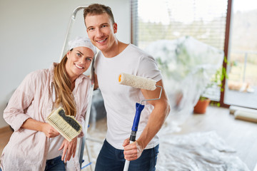 Glückliches Paar als Heimwerker beim Malern