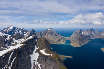 Fototapeta premium Aerial view of Reine, Lofoten islands, Norway. The fishing village of Reine. Spring time in Nordland. Blue sky. View from above.
