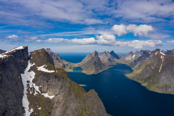 Obraz premium Aerial view of Reine, Lofoten islands, Norway. The fishing village of Reine. Spring time in Nordland. Blue sky. View from above.