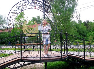 Girl standing on the bridge of lovers in the Park