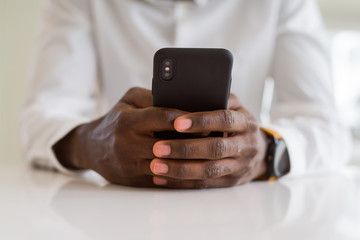 Close up of african man hands using smarpthone
