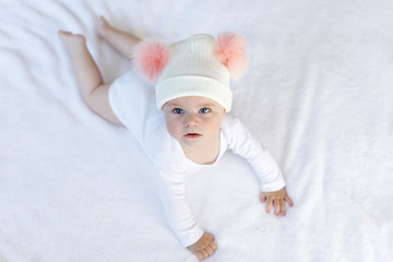 Cute adorable baby child with warm white and pink hat with cute bobbles