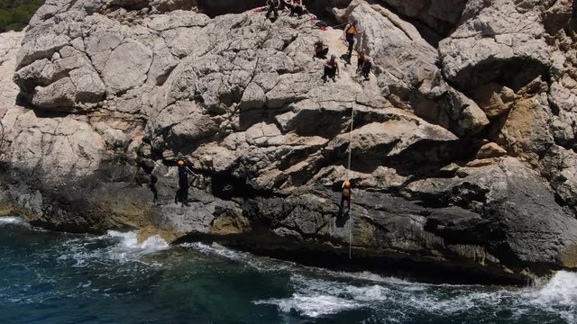 hombres de un equipo escalando una monta&ntilde;a en la costa de  Mallorca  en un d&iacute;a soleado 