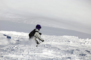 Naklejka na ściany i meble Female skier riding the slope
