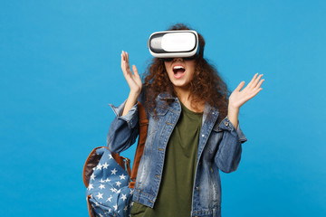 Young african american girl teen student in denim clothes, backpack headset vr isolated on blue...