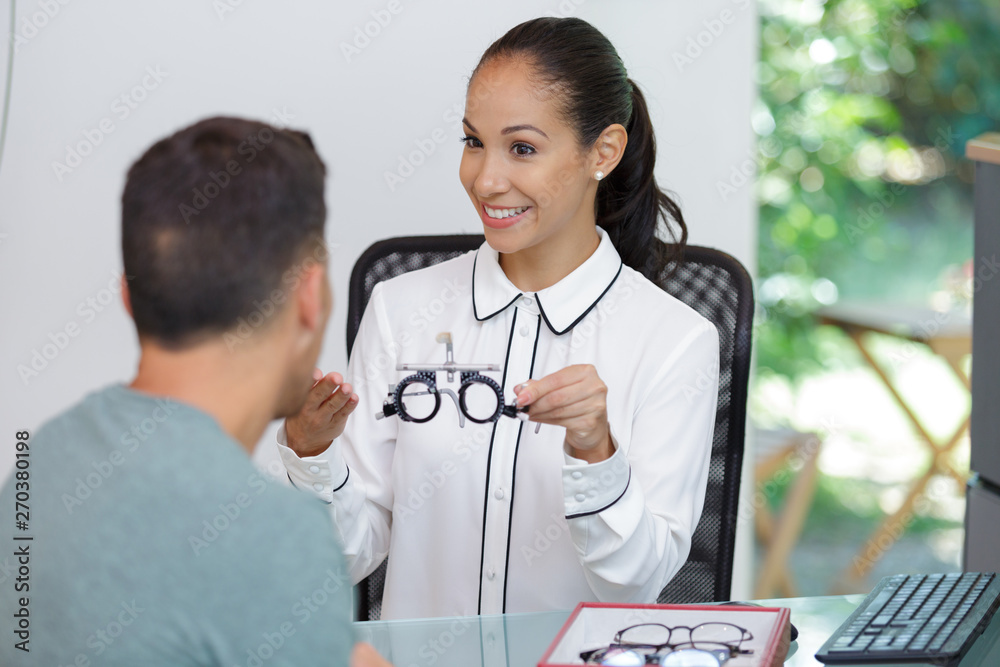 Wall mural ophthalmologist showing the glasses