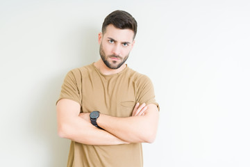 Fototapeta premium Young handsome man over isolated background skeptic and nervous, disapproving expression on face with crossed arms. Negative person.