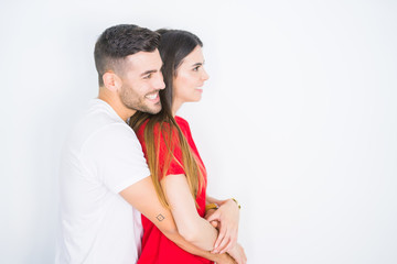 Fototapeta premium Young beautiful couple together over white isolated background looking to side, relax profile pose with natural face with confident smile.
