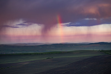 Naklejka na ściany i meble Rainbow and storm over the meadows.