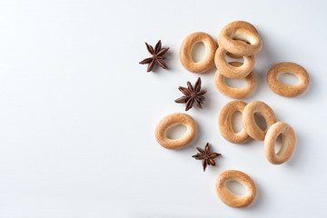 Pretzels and anise on the table. Badian and ring-shaped cracknel on the white field. Flat lay with star anise and bread. Background with spices and cookies.