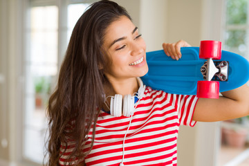 Beautiful skater woman smiling friendly standing with skateboard