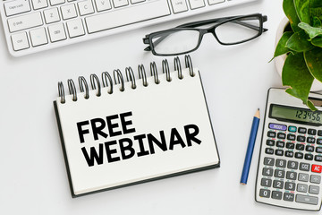 Free webinar. Top view of free webinar lettering notepad and pencil on white background