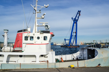 SEA CRANE AND BOAT - A large machine maneuvers at the port of Gdynia