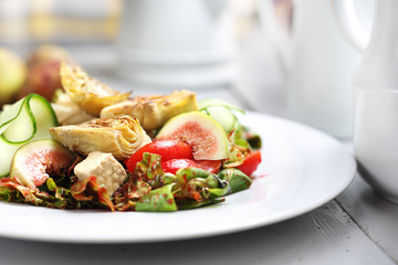 A light vegetarian salad with fig, artichoke, cucumber, tomatoes, feta on ruccola leaves, topped with raspberry sauce.