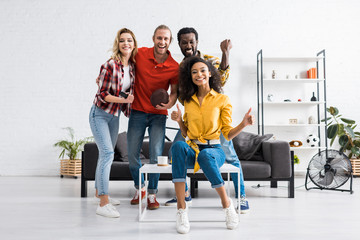 Fototapeta premium Czterech podekscytowanych wielokulturowych przyjaciół świętujących zwycięstwo i spędzających razem czas