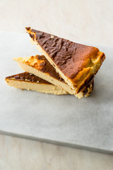 San Sebastian Cheesecake Slice on Marble Surface / Creamy Plain New York Style.