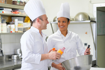 man and woman in chef uniform in the kitchen
