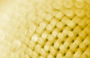 Abstract blurred yellow background. Texture of a metal mesh.