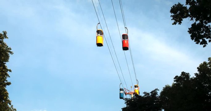 Cableway telpher on a background of blue sky in sunset time different colors diagonal movement