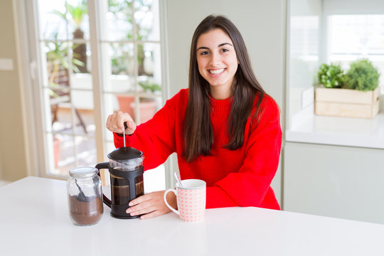 Young beautiful woman making morning coffee smiling, preparing a cup of latte for breakfast