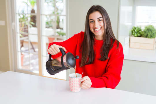 Young beautiful woman making morning coffee smiling, preparing a cup of latte for breakfast