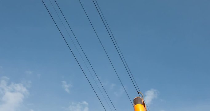 Cableway telpher on a background of blue sky in sunset time different colors diagonal movement