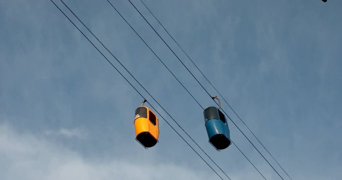 Cableway telpher on a background of blue sky in sunset time different colors diagonal movement