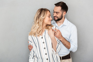 Photo of romantic couple in casual clothing smiling and hugging each other
