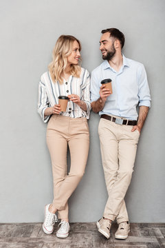 Full Length Photo Of European Couple In Casual Clothing Holding Paper Cups And Looking At Each Other