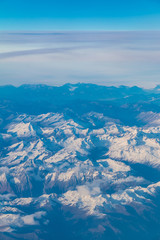 Fototapeta na wymiar View from the porthole of airplane of a beautiful mountain landscape
