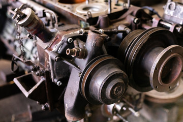 Obraz na płótnie Canvas Mechanic repairs old motor of truck in a car repair station. Disassemble engine block vehicle. Motor capital repair. Car service concept