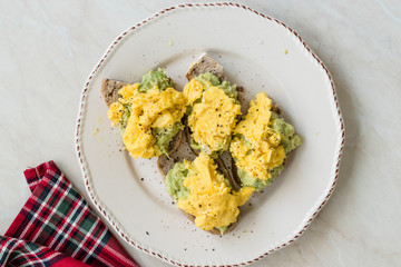 Scrambled Eggs with Avocado on Toast Bread for Breakfast.