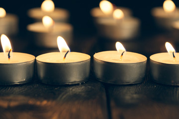 candles burning in darkness over black background. commemoration concept.
