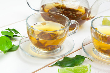 teapot and cups of tea on a white wooden background