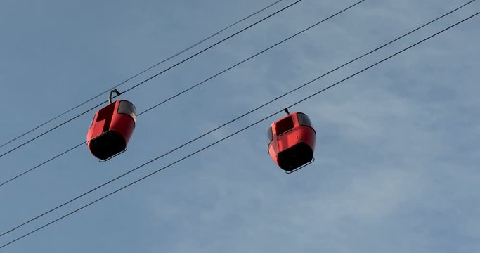 Cableway telpher on a background of blue sky in sunset time different colors diagonal movement