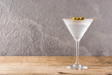 Classic Dry Martini with olives on gray stone background