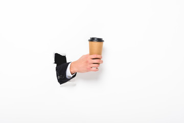 Cropped view of man holding coffee to go from hole in wall on white with copy space