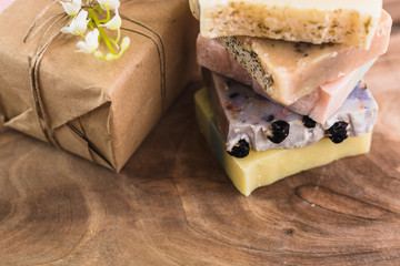 colorful handmade soaps and gift box on wooden background