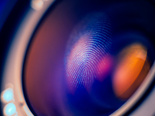 Fingerprint macro on a lens in blue light, shallow depth of field. Biometric and security concept.