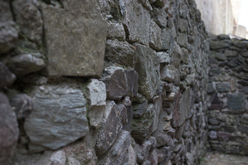 Close up of various shaped stone wall of medieval fortress.