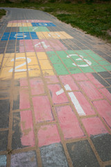 Children game hopscotch on pavement