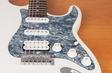 Fototapeta na wymiar Part of white electric guitar, studio shoot. 2 x Single Coil and 1 x Humbucking. Black Pearl pickguard, Rosewood Fingerboard