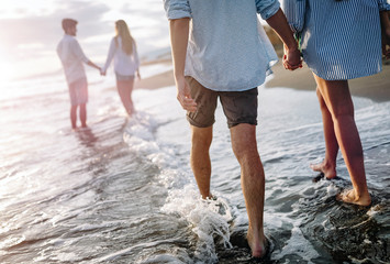 Happy cheerful couple having fun on a tropical beach at sunset