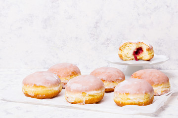 Traditional Polish donuts with frostng on light background. Tasty doughnuts with jam.