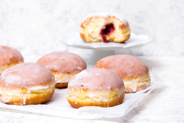 Obraz na płótnie Canvas Traditional Polish donuts with frostng on light background. Tasty doughnuts with jam.
