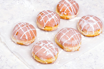 Traditional Polish donuts with white frosting on wooden background. Tasty doughnuts with jam.