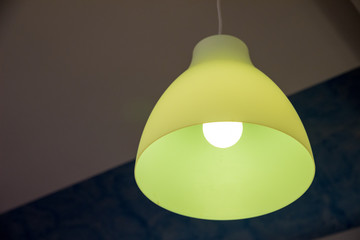 A yellow lit chandelier view from the bottom